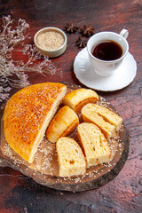 top view tasty sweet pastry sliced in pieces with tea on dark desk dough cake pie