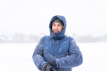 40s portrait of smiling man in winter clothes in heavy snow