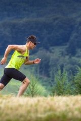 Athletic man runner running in mountains
