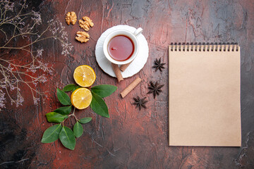 Obraz na płótnie Canvas top view cup of tea with lemon on dark background tea fruits dark photo