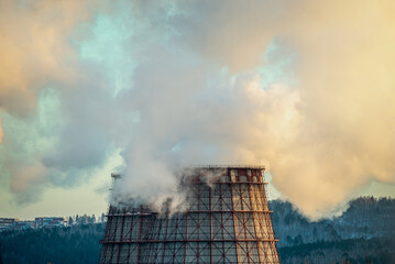 Powerful industrial factory chimney is smoking and polluting the environment with carbon dioxide