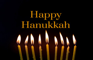 burning candles on a dark background and text Happy Hanukkah