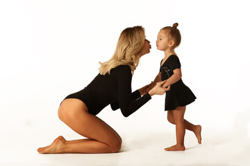 cute baby girl and mum in black bodies having fun full body studio portrait