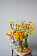 Fototapeta na wymiar Set of yellow nd orange flowers for Interior decorations. The work of the florist at a flower shop. Fresh cut flower. European floral shop. Delivery fresh cut flower