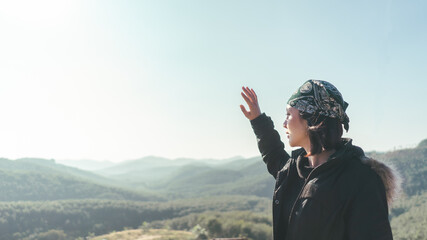 Hipster Asian woman traveller looking view on peak mountain on the morning. Hiker woman in coat on the mountains.