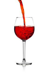 In a transparent glass, a stream of wine pours creating excitement on a white background