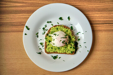 A home made sandwich of avocado and a poached egg. Healthy and healthy food. High quality photo