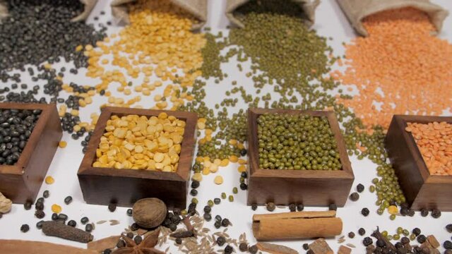 A view of Urad  Moong  Arhar  and Masoor Dal/lentils with Indian whole spices . Closeup view of whole spices like cumin  cinnamon  nutmeg  ginger  cloves  black pepper  and star anise with various ...