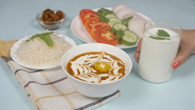 Summer cooler buttermilk drink made of yogurt/dahi placed with dal chawal meal. Popular Indian lunch of Dal Makhani and steamed rice served with fresh salad  Achaar/pickle  and Chaas/buttermilk kep...