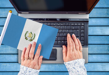 woman hands and flag of Guatemala on computer, laptop keyboard 