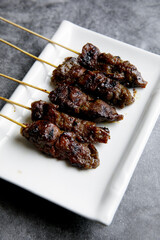 Beef and mutton satay on a white plate
