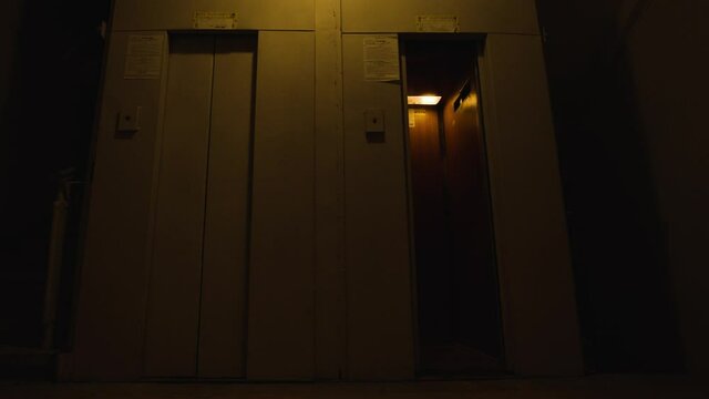 Old elevators in entrance. Stock footage. Lift's narrow doors open and close. Old narrow elevators in residential building. Two small elevators for couple of people