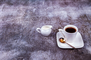 Espresso coffee in white porcelain cup and cream in a portioned jug