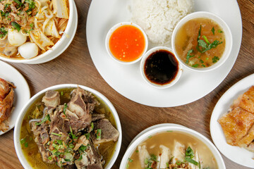 a flat lay of chicken rice, curry noodles, beef soup and chicken porridge