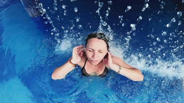 Woman enjoying indoor pool and hydrotherapy, slow motion