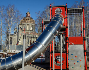 Children's play construction against the backdrop of an Orthodox Cathedral under construction in Chelyabinsk, Russia.