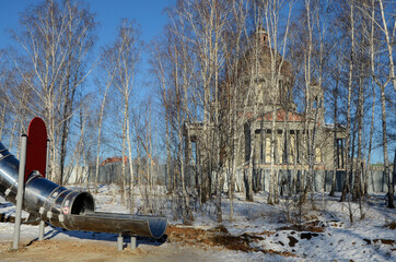 Children's play construction against the backdrop of an Orthodox Cathedral under construction in Chelyabinsk, Russia.