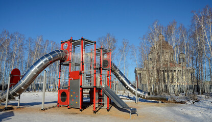 Children's play construction against the backdrop of an Orthodox Cathedral under construction in Chelyabinsk, Russia.
