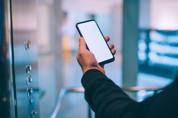 Mock-up technology. The guy holds a smartphone in his hands on the background supermarket.