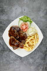 a plate of lamb chop set come with french fries and coleslaw