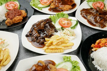 a plate of black paper steak set come with french fries and coleslaw