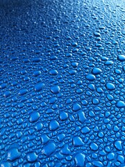 Condensation water droplets on blue metallic background with copy space