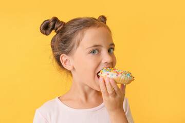 Cute little girl with sweet donut on color background