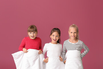 Cute little girls with blanket on color background