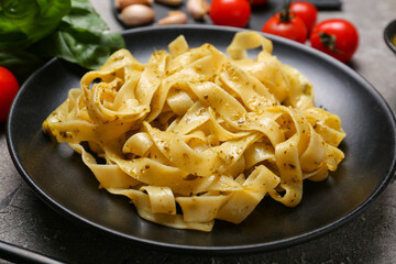 Plate with tasty pasta and pesto sauce on table, closeup