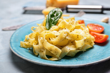 Plate with tasty pasta and pesto sauce on table, closeup