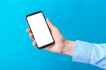 Hand with mobile phone on color background