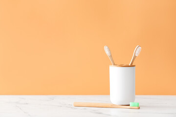 Holder with wooden toothbrushes on table
