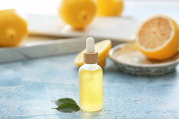 Bottle with lemon essential oil on table