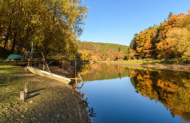 autumn view at river Mze next city Stribro with boat and reflections in water on sunny day