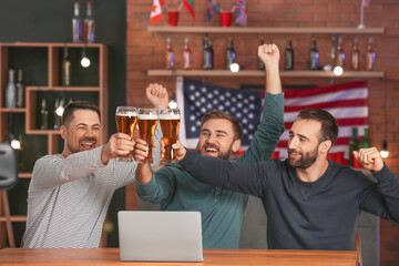 Happy men after winning of their sports bets in pub