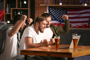 Happy men after winning of their sports bets in pub