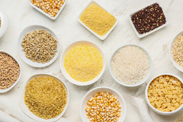 Bowls with assortment of cereals on white background
