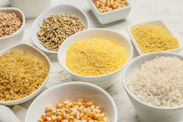 Bowls with assortment of cereals on white background