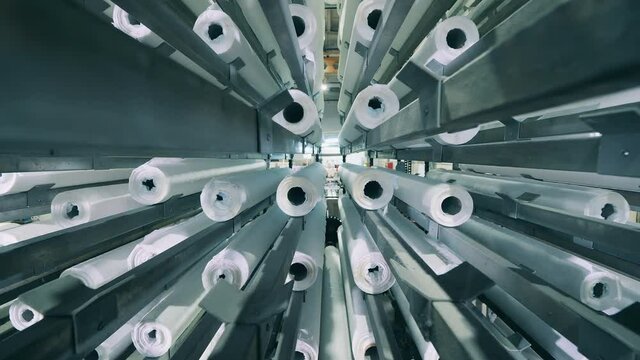 Inside view of a factory mechanism transporting paper rolls