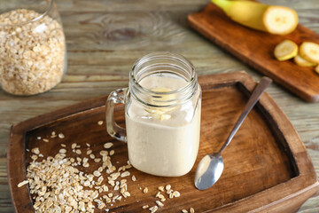 Mason jar of tasty banana smoothie on table