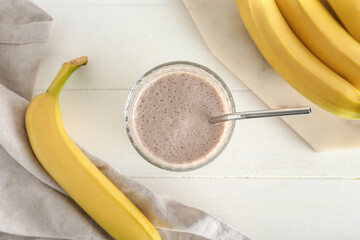Glass of tasty banana smoothie on table