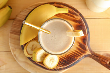 Glass of tasty banana smoothie on table