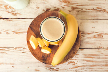 Glass of tasty banana smoothie on table