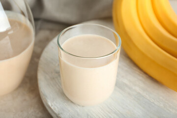 Glass of tasty banana smoothie on table
