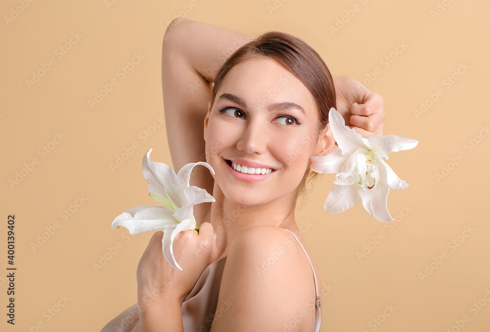 Wall mural beautiful young woman with fresh lilies on color background