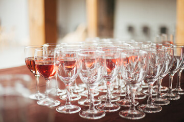 Catering. Lots of wine glasses. There are many glasses on the table. Glass wine glasses.