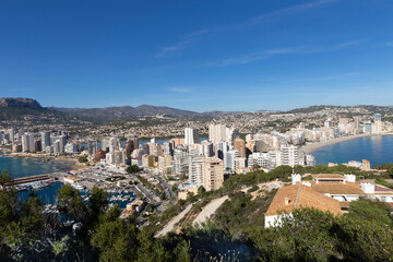 Fototapeta premium Coastline of the Mediterranean resort of Calpe, Spain with sea and yachts, lake, skyscrapers and mountain range.
