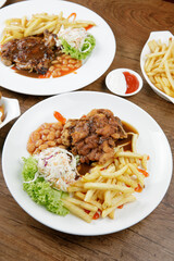 a plate of black paper steak set come with french fries and coleslaw