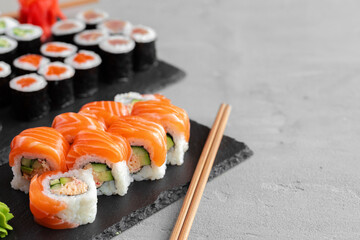 Sushi roll covered with fresh salmon served on plate