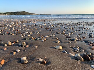 Beautiful pebbles on the sand, beach background